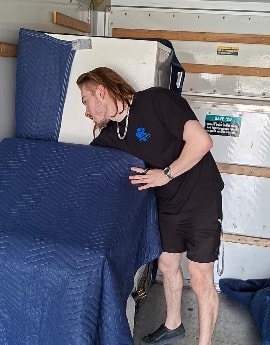 Déménageur emballant un meuble dans le camion